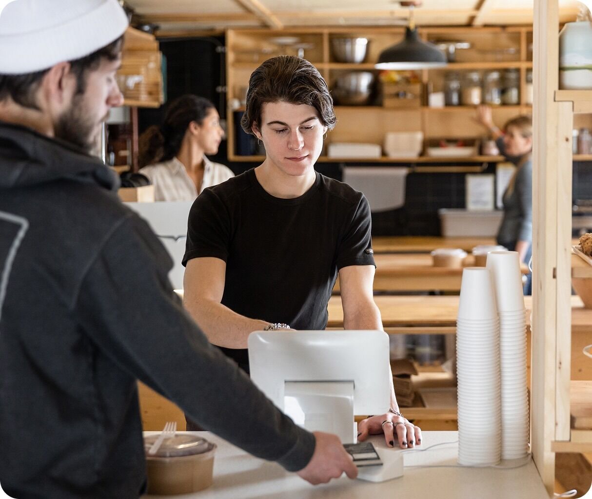 Restaurant employee working at a point-of-sale terminal behind the counter