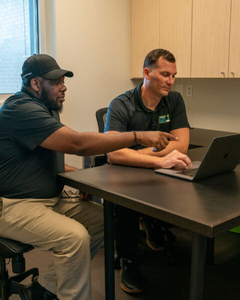 Team reviewing a unified security system configuration on laptop