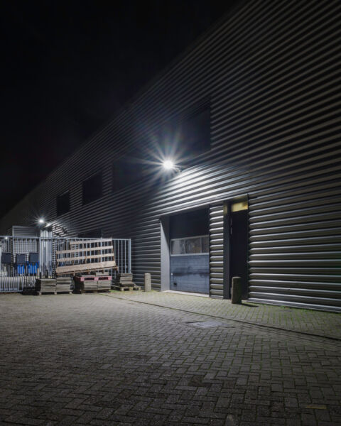 outside of a building with lights on the wall at night