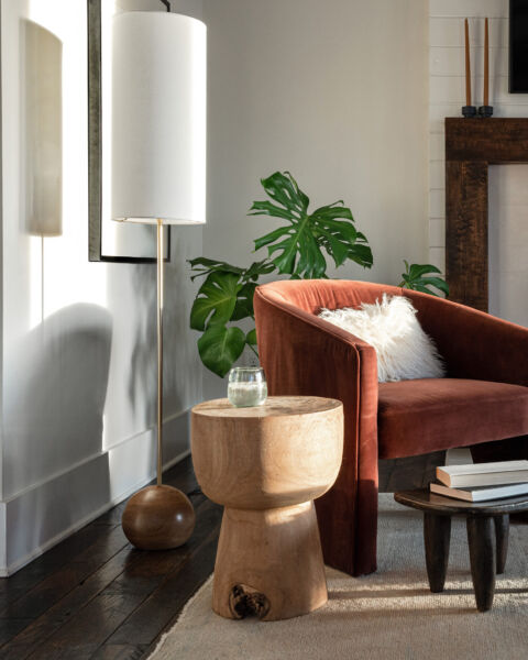 Living room with a lit fireplace, armchair, and coffee table