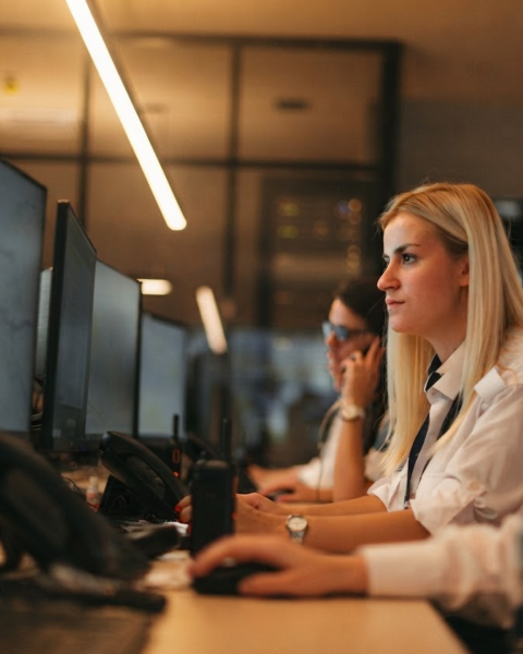 Two remote monitoring operators reviewing live video alerts at a workstation