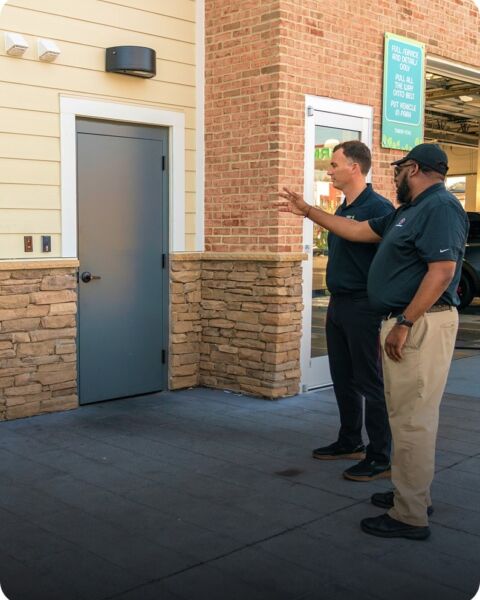 Security installer talking with a property owner outside a commercial back door