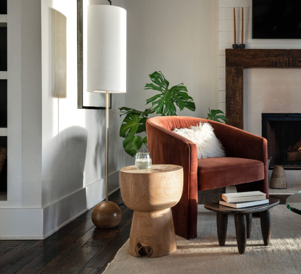 Living room with a lit fireplace, armchair, and coffee table
