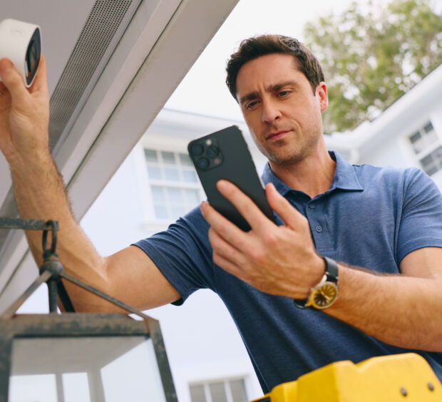 Man installing camera on a home