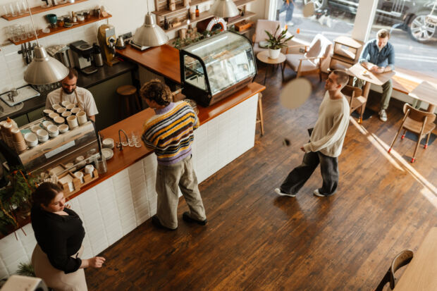 people in a cafe walking and standing